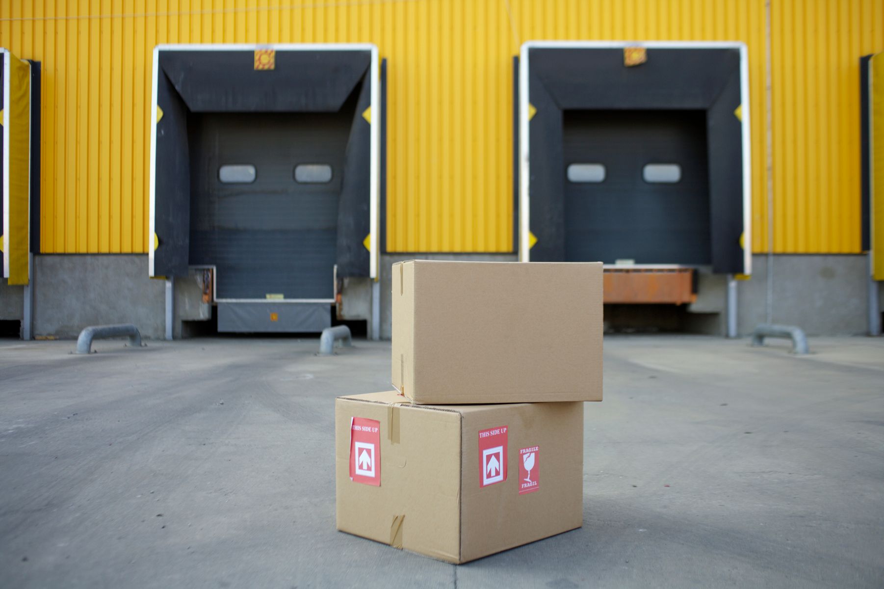 Plain cargo cartons staged in front of warehouse loading bays