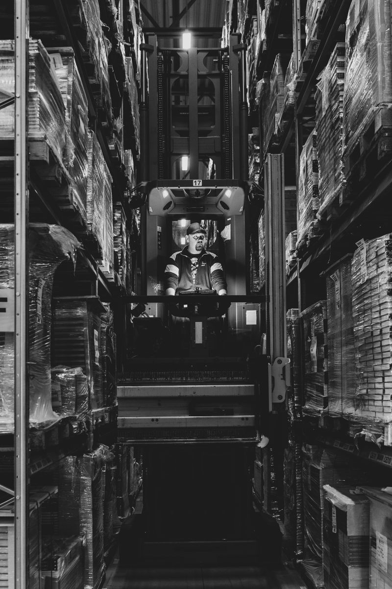 Forklift operator moving through a warehouse aisle