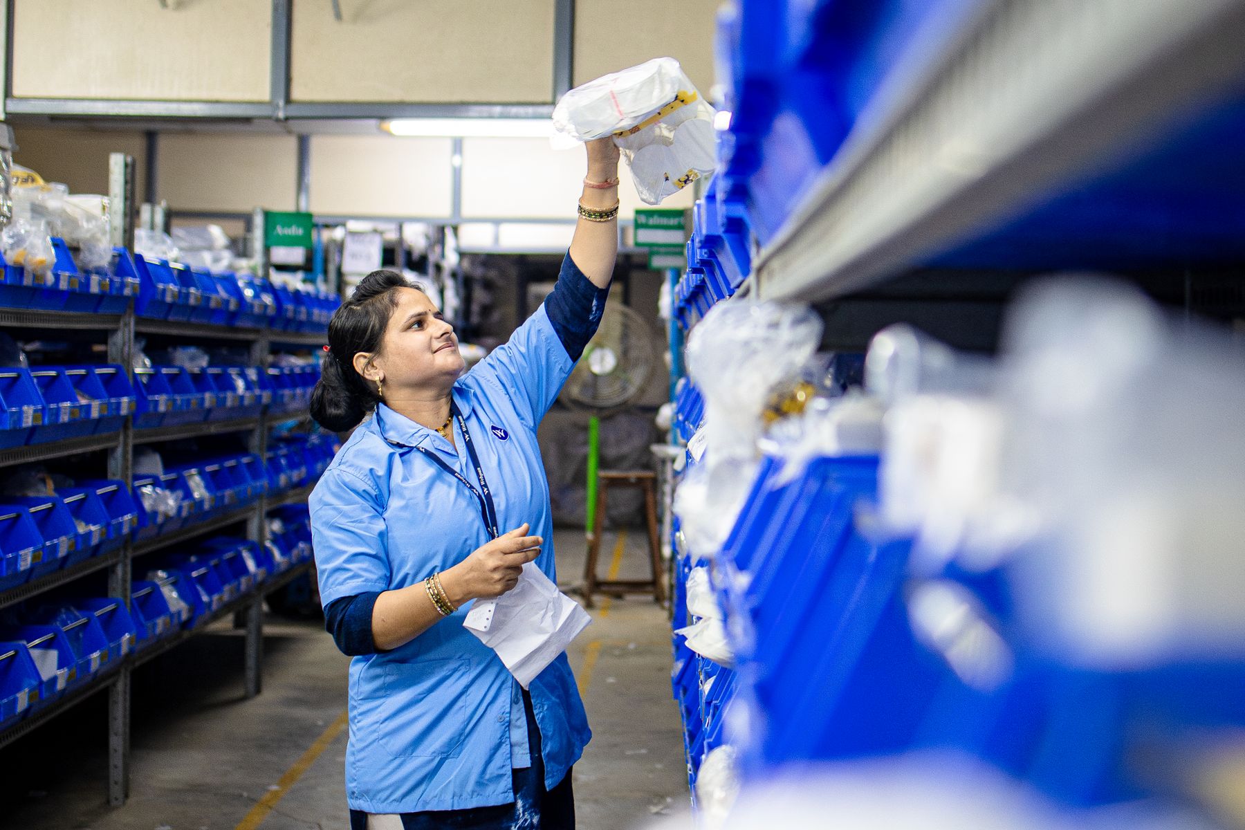 Warehouse worker organizing parts in storage bins